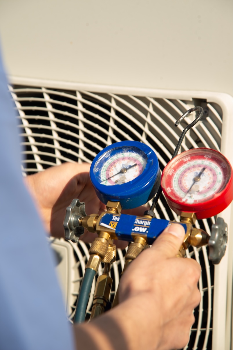 Technician checking refrigerant pressure